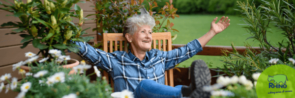 Elderly woman enjoys rocking in a chair in her garden
