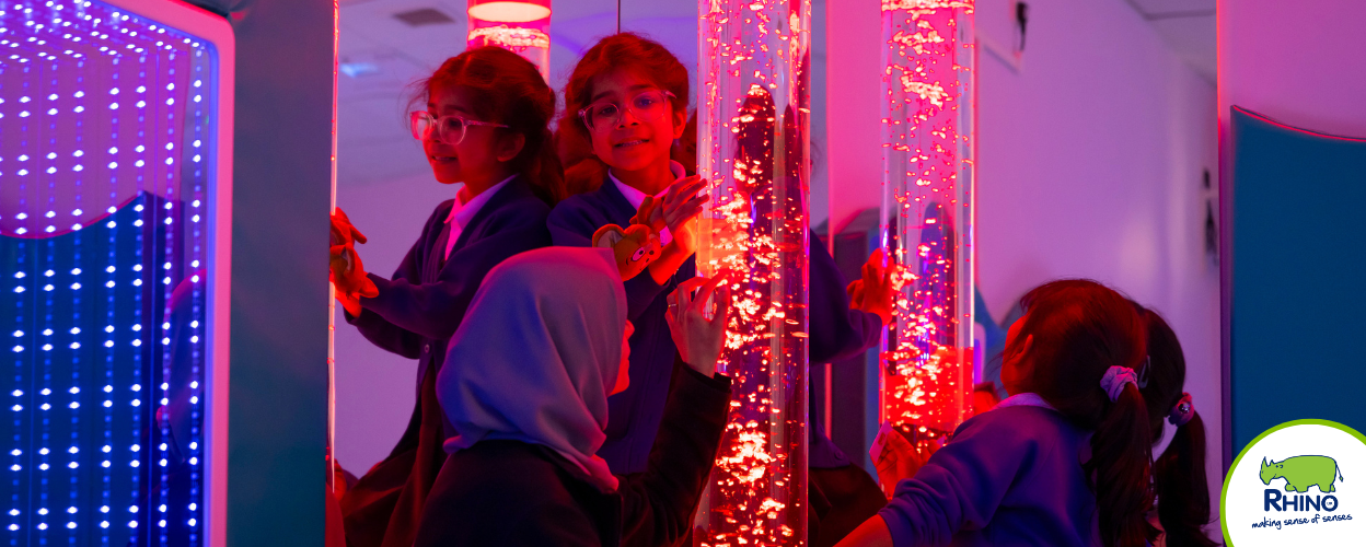 Students and a teacher explore the interactive light effects of a bubble tube.