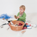 Toddler playing with the tactile items inside the Discover Baskets