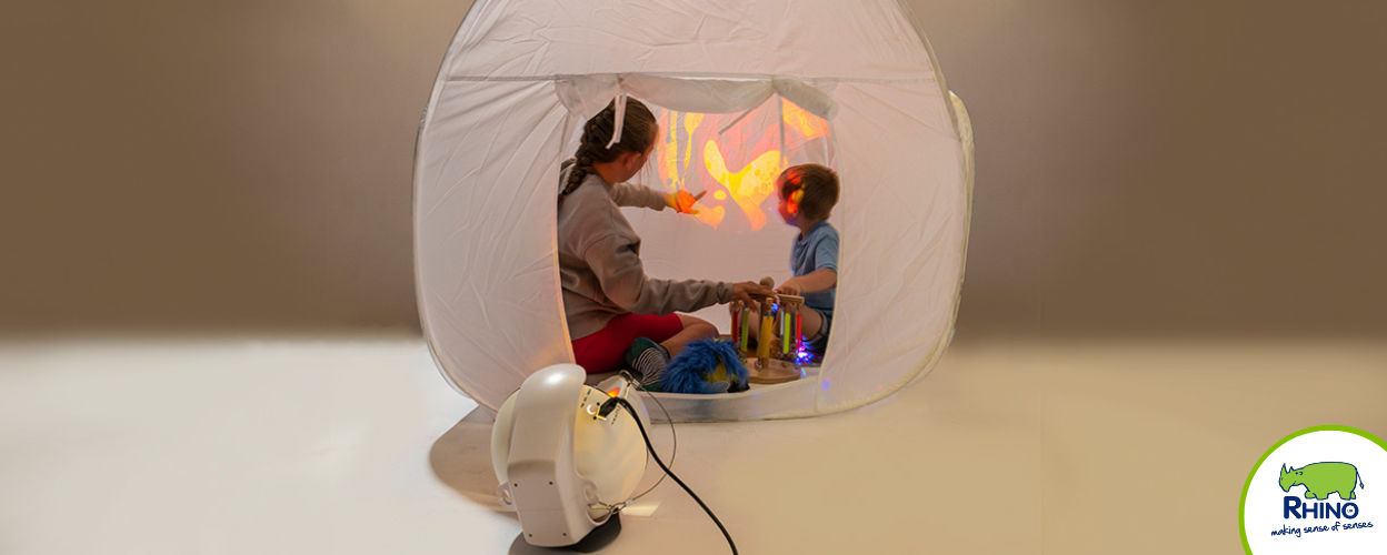 Two children sitting inside a pop up sensory den.