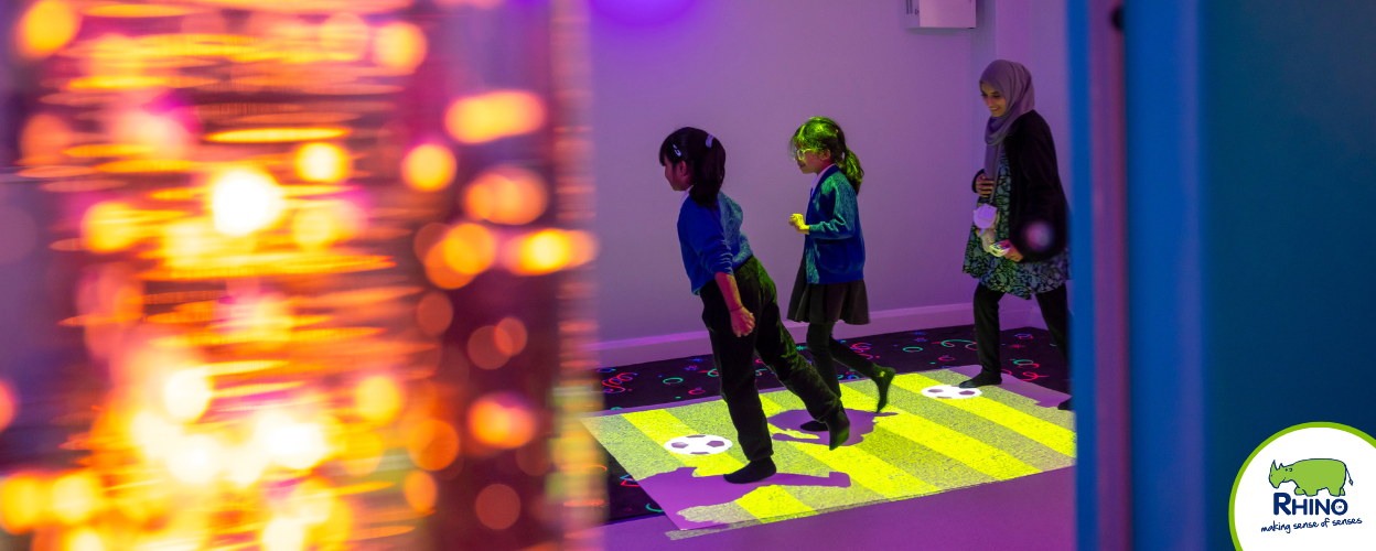 Students and a teacher have fun with an interactive floor projector.