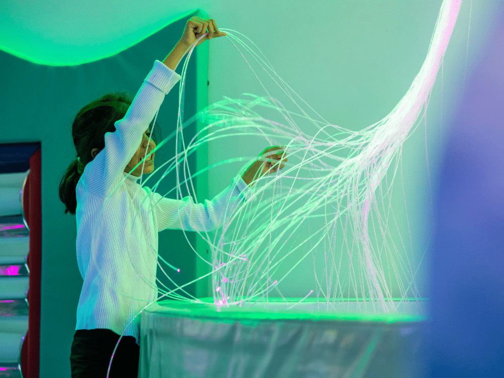 A girl holds and separates the fibre optic tails, exploring their twinkle glow effect
