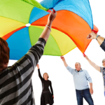 Older people therapeutically playing with a parachute