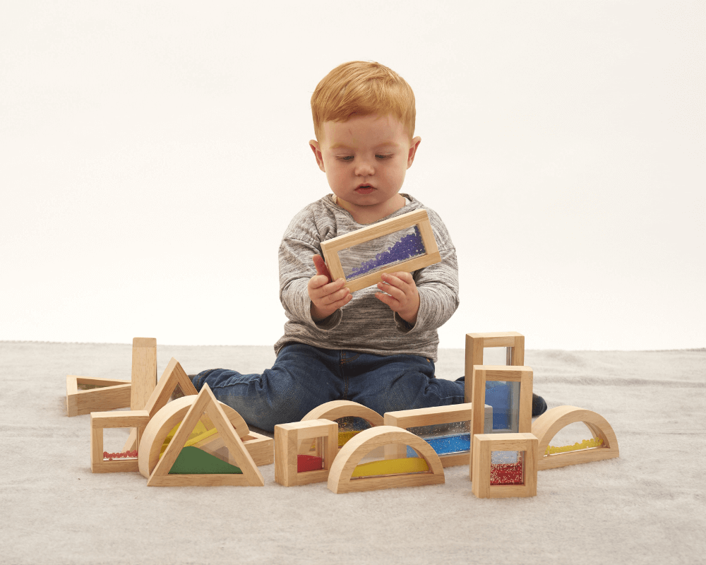 Young boy exploring his tactile senses with sensory blocks