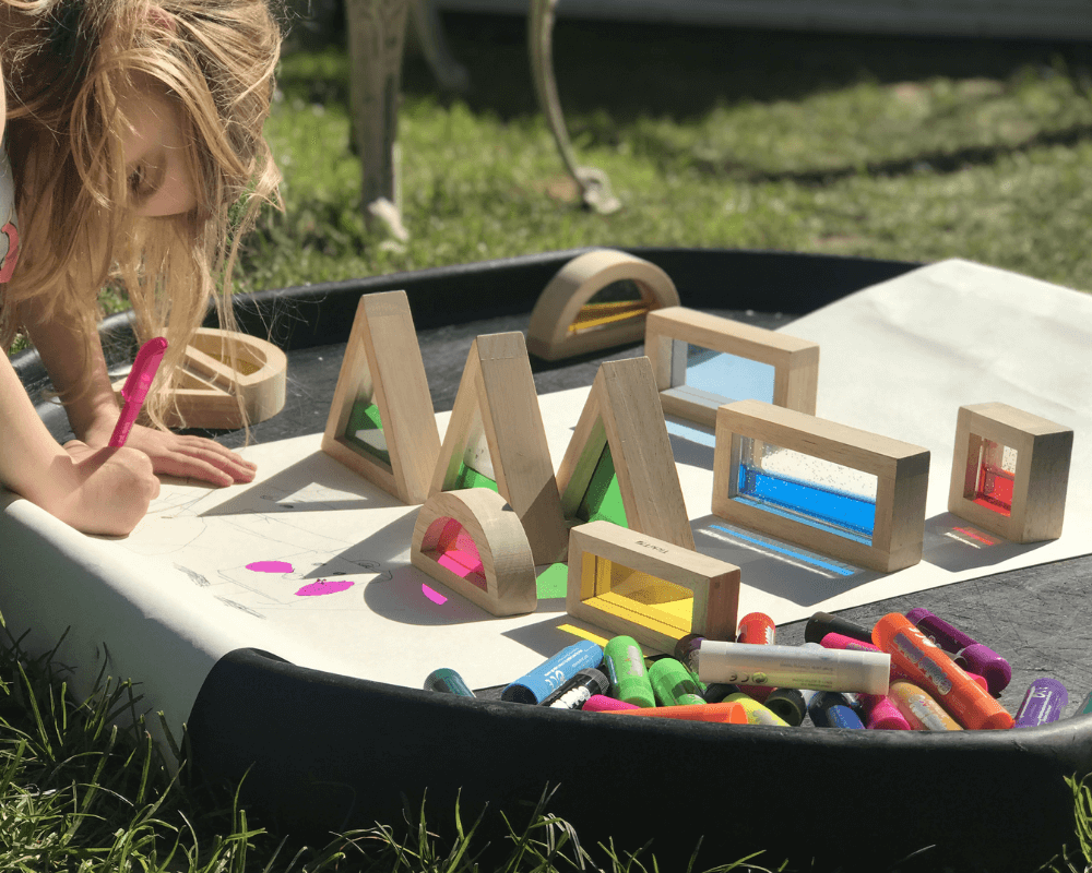 Girl plays with sensory blocks outside in the sun