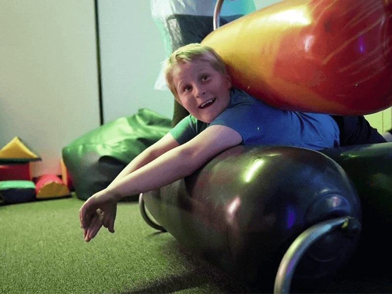 Boy squeezes through a bodyroller at More Rehab Occupational Therapy Centre