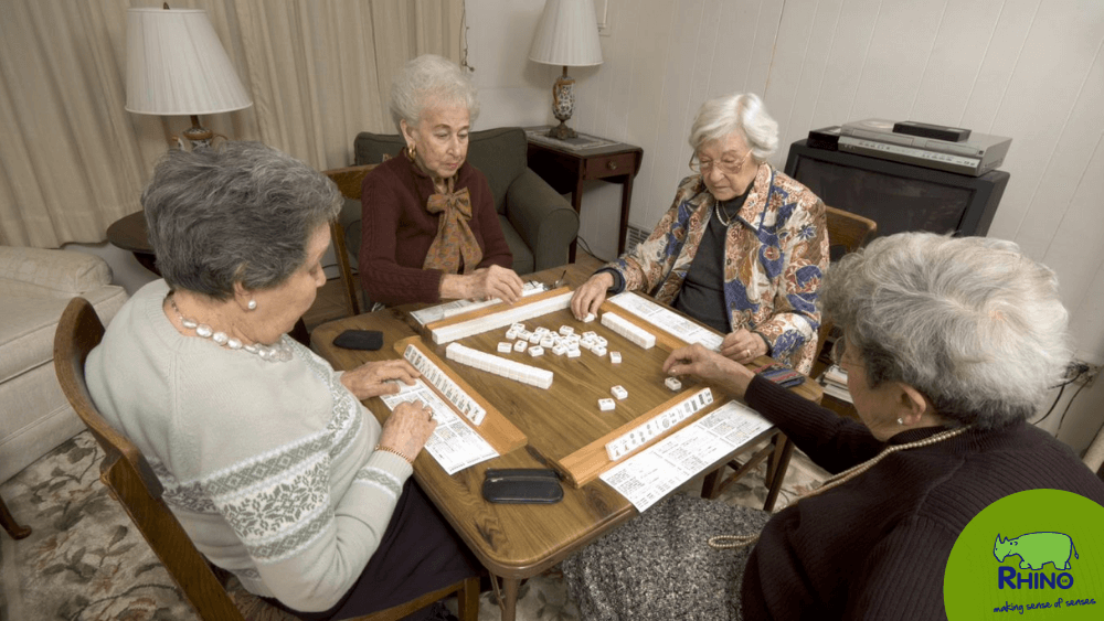 Elderly residents socialise over a board game.